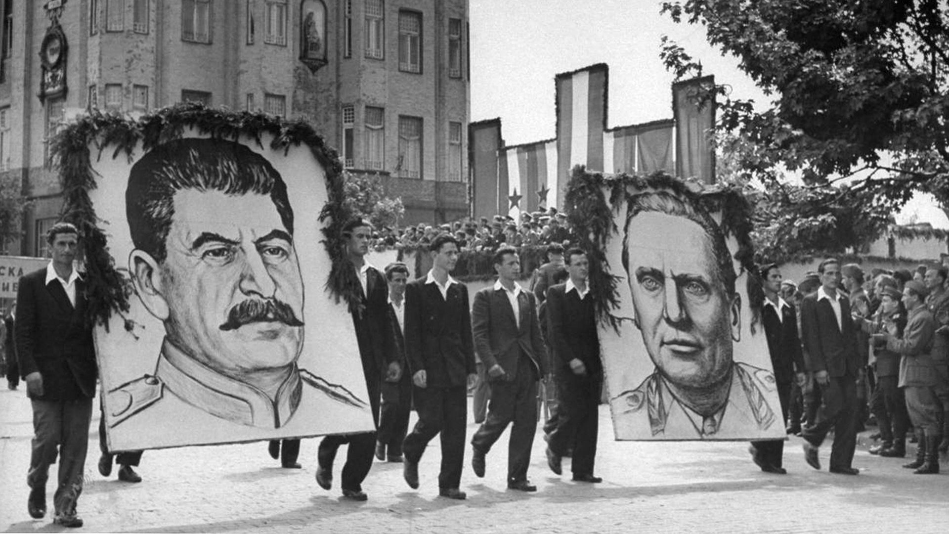 Ein Umzug mit großen Porträts von Stalin und Tito