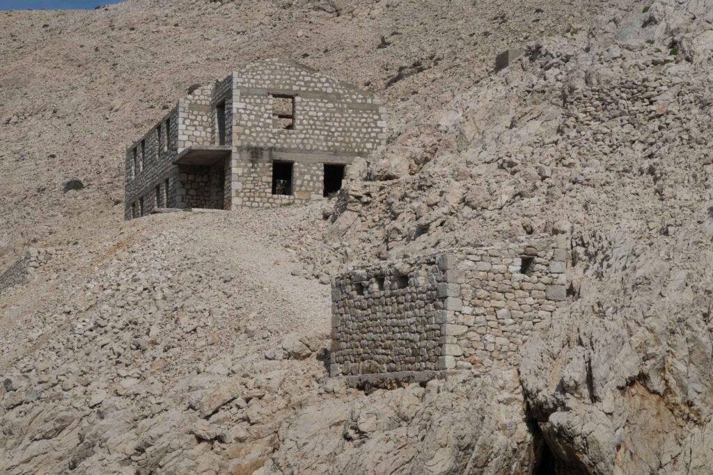Ruine eines zweigeschossigen Steingebäudes an einem Hang
