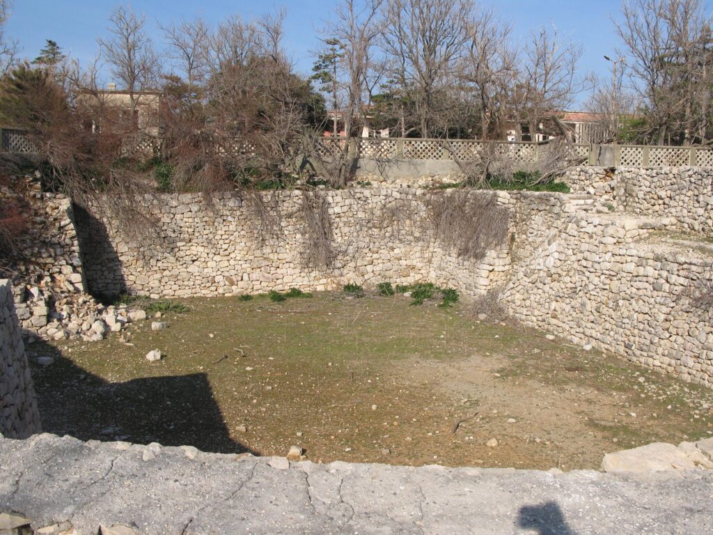 Rand einer runden Grube mit Steinmauer