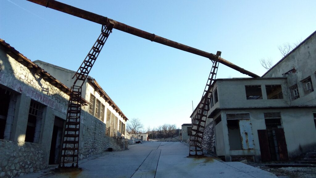 Reihe von Gebäuden der Strafanstalt an einer Straße, mit einem Metallgerüst eines Krans
