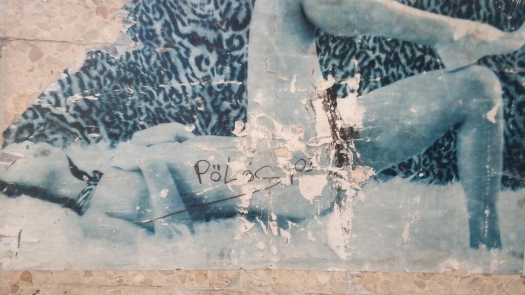 Verblasstes Wandbild mit einer Figur auf blauem Hintergrund